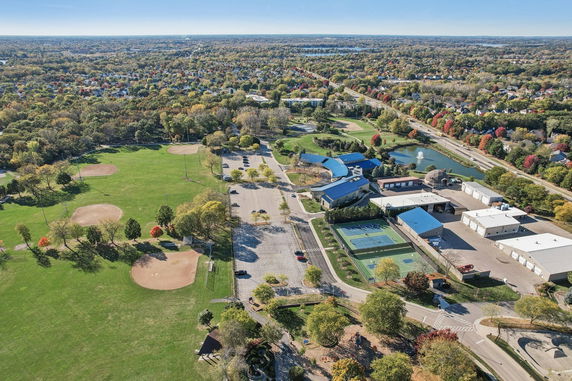 Aerial view of a large park with baseball fields, parking area, and surrounding community.
