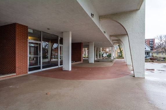 Front view of a building with large glass doors and brick columns.