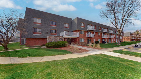 Front view of a multi-story apartment building with balconies.