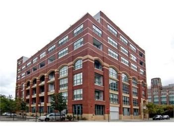 Front view of a multi-story brick building with large windows.