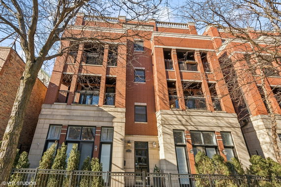 Front view of a multi-story brick building with balconies.