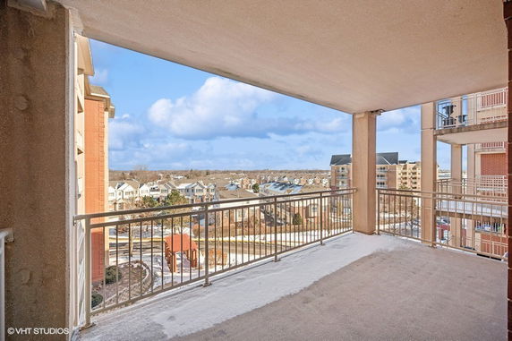 View from a balcony overlooking residential buildings and landscape.