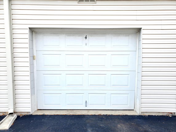 Front view of a house garage with a white door.