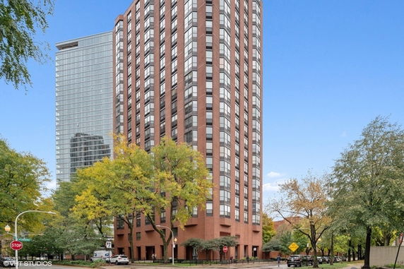 Front view of a tall, multistory brick building with large windows.