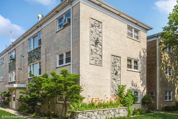 Front view of a multi-story brick building with stone accents and multiple windows.