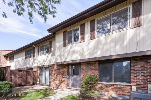 Front view of a two-story townhouse with brick and siding exterior.