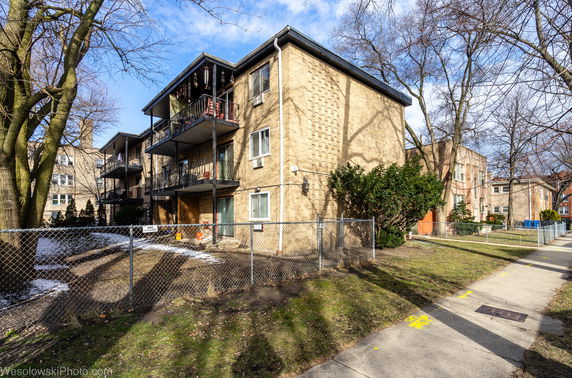 Front view of a three-story apartment building with balconies.