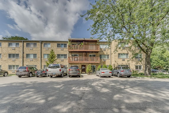 Front view of a three-story apartment building with multiple balconies.