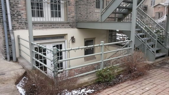 Side view of a multi-story building with an external staircase and railing.