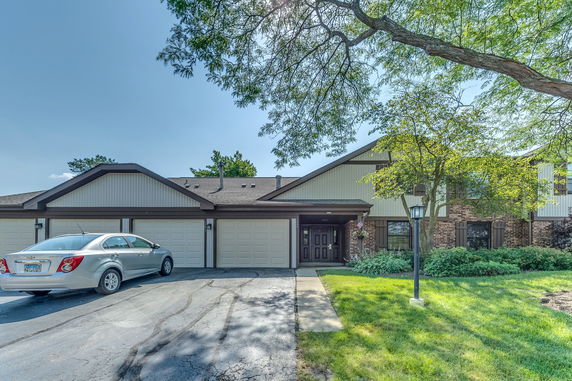Front view of a house with a three-car garage and brick facade.