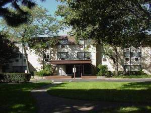 Front view of a multi-story residential building with a canopy entrance.