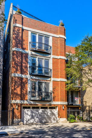 Front view of a multi-story brick building with balconies.