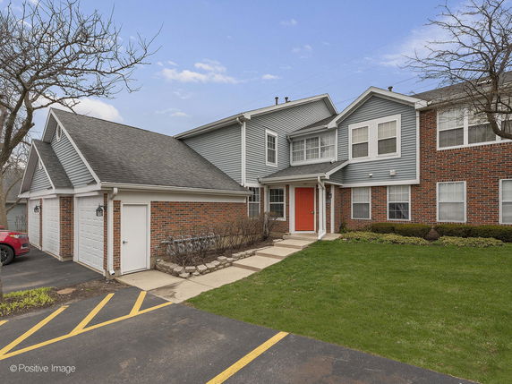 Front view of a two-story house with red door and double garage.
