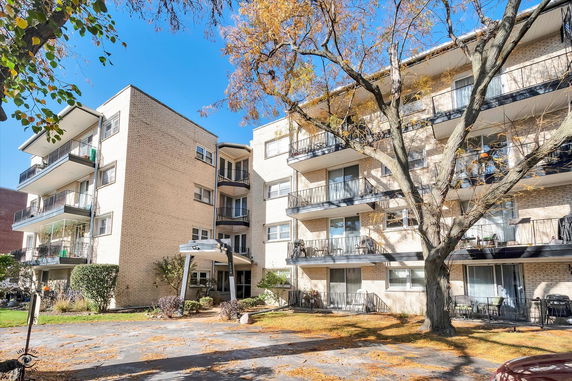 Front view of a multi-story residential apartment building with balconies.