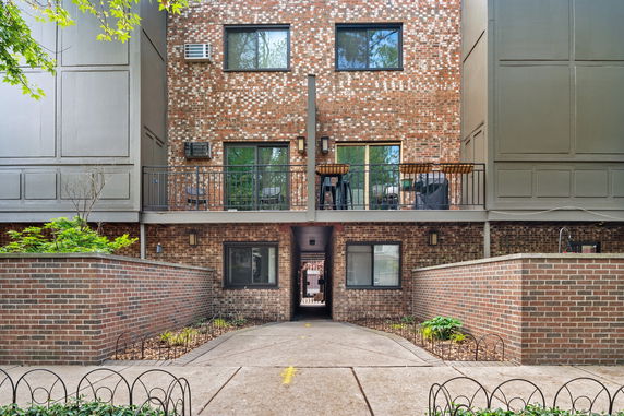 Front view of a multi-story brick building with a balcony.
