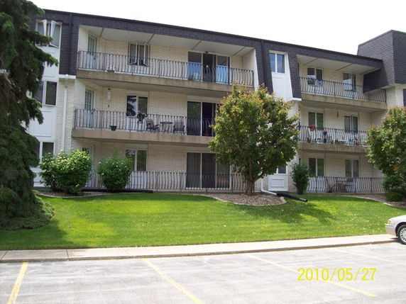 Front view of a multi-story apartment building with balconies.