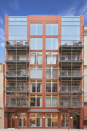 Front view of a multistory building with balconies and large windows.
