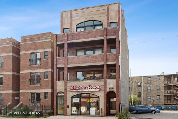 Front view of a multi-story building with a business on the ground floor.