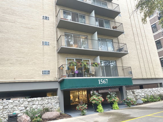 Front view of a multi-story apartment building with balconies.