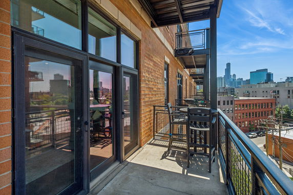 Balcony view from an apartment building with city skyline in the background.