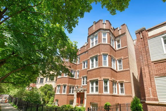 Front view of a multi-story brick building with multiple windows.