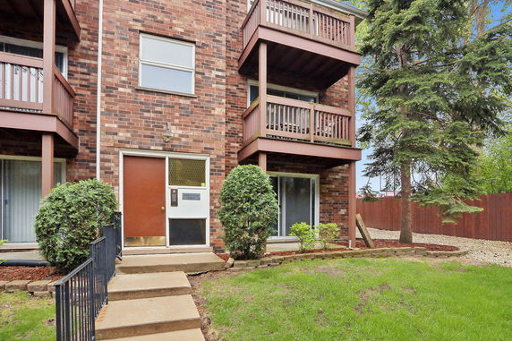Front view of a residential building with brick exterior and balconies.