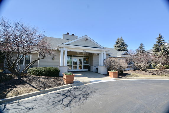 Front view of a single-story building with a covered entrance and columns.