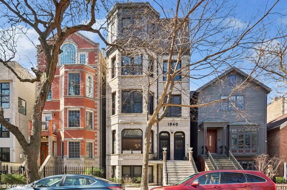 Front view of a row of multi-story townhouses with different architectural designs.