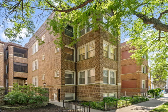 Front view of a brick apartment building with multiple windows.