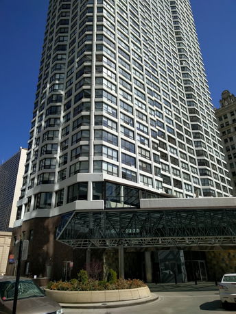 Front view of a tall multi-story building with modern architectural design.