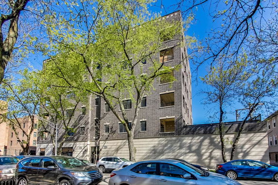 Front view of a multi-story apartment building with brick exterior.
