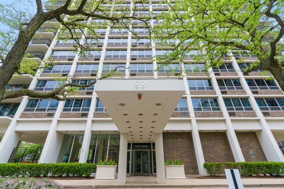 Front view of a multi-story residential building with a covered entrance.