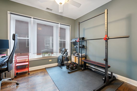 Indoor gym area with exercise equipment and a weight rack.