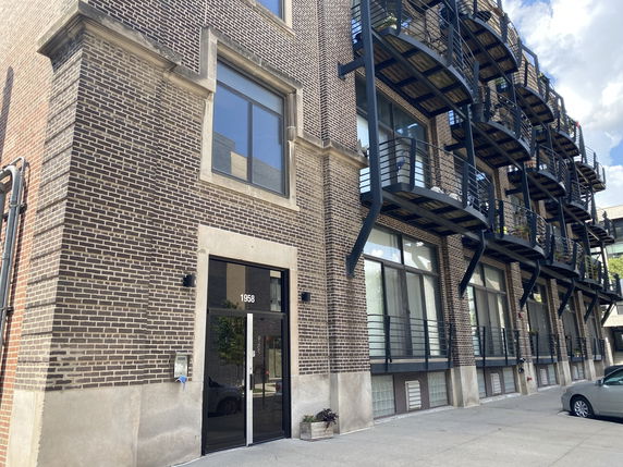 Front view of a building with brick exterior and multiple balconies.