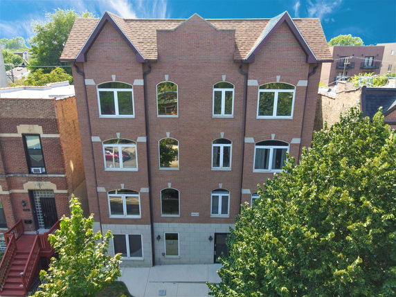 Front view of a four-story brick building with multiple windows.