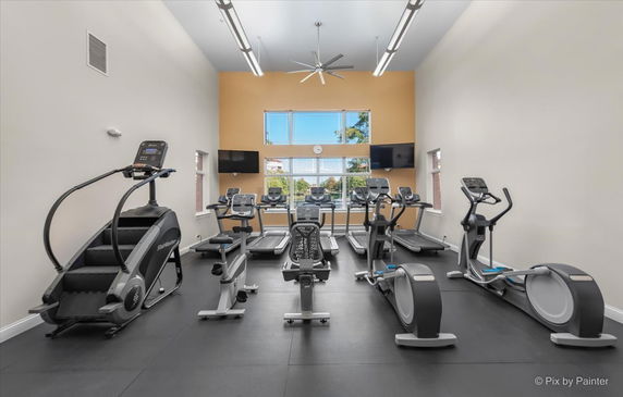 Interior view of a gym with various exercise equipment including treadmills and ellipticals.