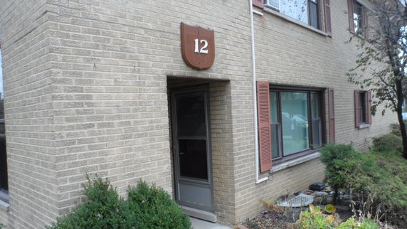 Front view of a brick building with a door and windows.