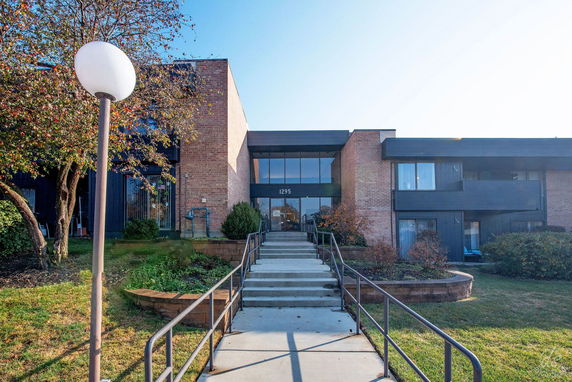 Front view of a modern brick building with large windows and a central entrance.
