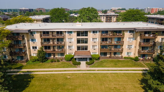 Front view of a multi-story apartment building with balconies.