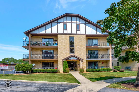 Front view of a three-story apartment building with balconies.