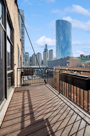 View from a building balcony overlooking a cityscape with tall buildings.