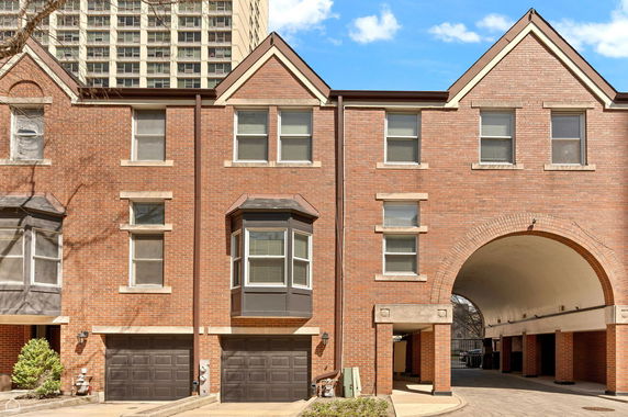 Front view of a brick building with multiple garage doors and arched passageway.
