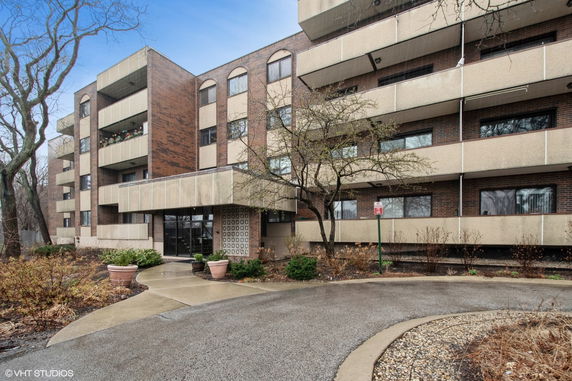 Front view of a multi-story brick and concrete building with balconies.