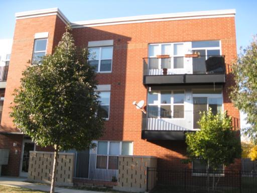 Front view of a three-story brick building with balconies.