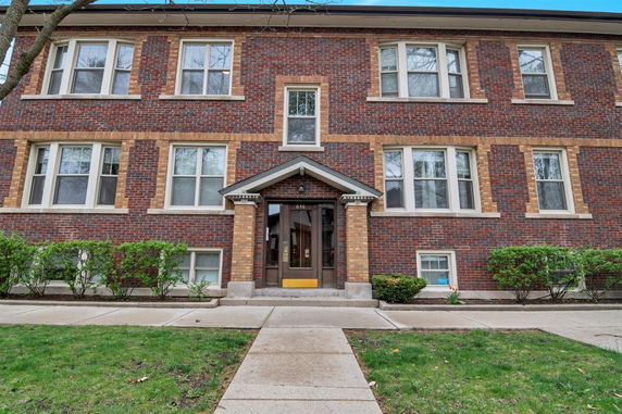 Front view of a two-story brick building with multiple windows.