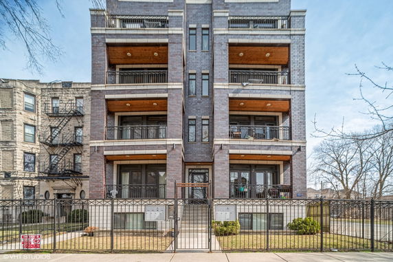 Front view of a multi-story apartment building with balconies.