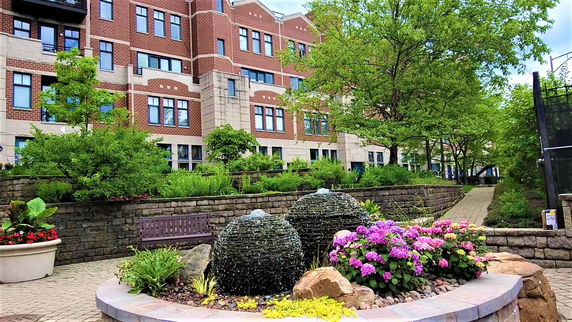 Front view of a multi-story building with brick facade and decorative landscaping.