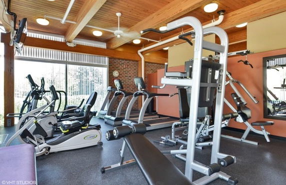 Indoor gym area with exercise equipment including treadmills and weight machines.