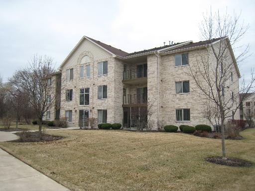 Front view of a multi-story apartment building with a gabled roof.