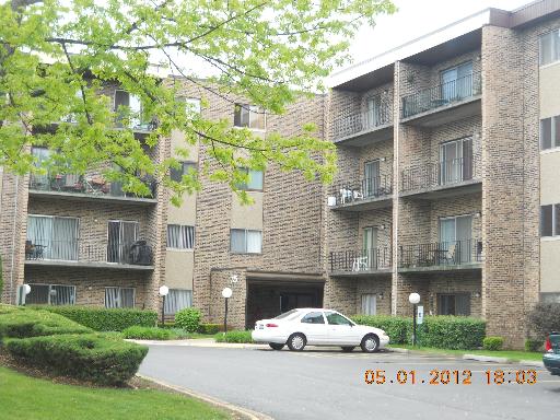 Front view of a multi-story apartment building with balconies.